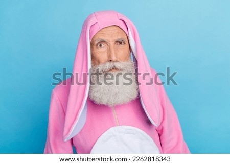 Photo of doubtful unsure retired man wear pink hare pajama suspiciously looking you isolated blue color background
