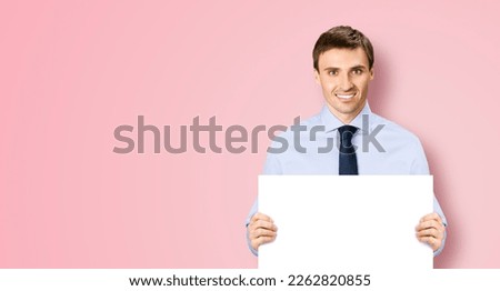 Portrait image of business man professional bank manager in confident cloth necktie holding showing empty white banner signboard paper poster with copy space area. Isolate on rose pink background
