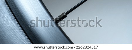 Macro of bicycle wheel focused on the rim and a single spoke in shades of gray and bluish gray in a 1x3 format. Room for copy.
 Royalty-Free Stock Photo #2262824517