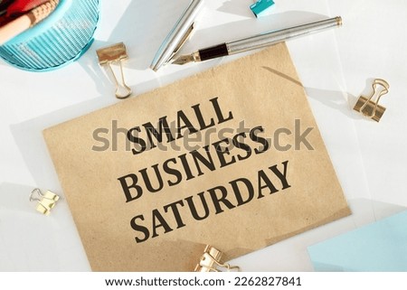 Text Small Business Saturday on envelope on white table with office tools Royalty-Free Stock Photo #2262827841