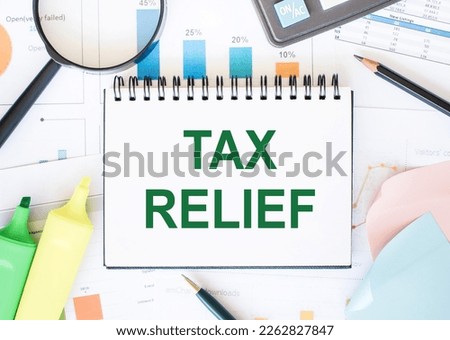 TAX RELIEF text on notebook with magnifier and calculatir on a white background