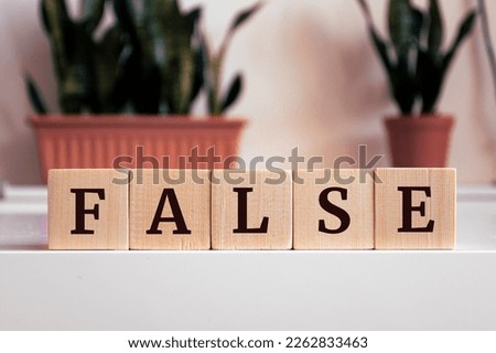The word 'False' written on wood cube. Misleading information concept. Royalty-Free Stock Photo #2262833463