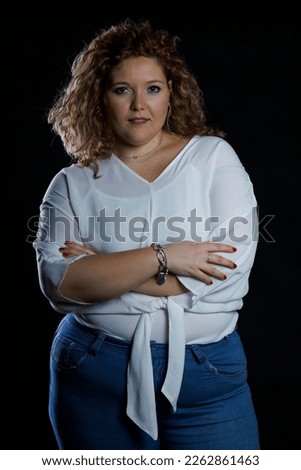 Plus size fashion model, fat woman in denim clothes and white shirt on black background, overweight female body