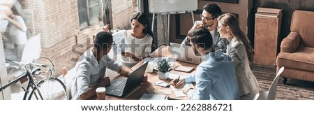 Group of young business people discussing strategy while having meeting in the office Royalty-Free Stock Photo #2262886721