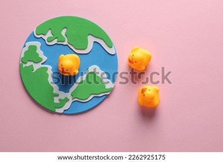 Planet earth with rubber ducks on a pink background.