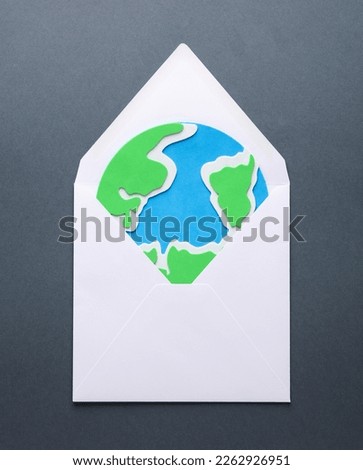 Envelope with the planet earth on a gray background