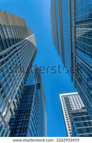 View of modern commercial buildings in downtown Austin Texas against blue sky. The towering skyscrapers have glass walls with reflections on this sunny day.