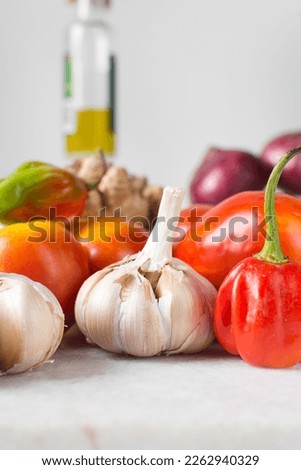Garlic bulbs and tomatoes on a marble tray, raw garlic and tomatoes for making pasta and pizza sauce, Allium sativum and Solanum lycopersicum