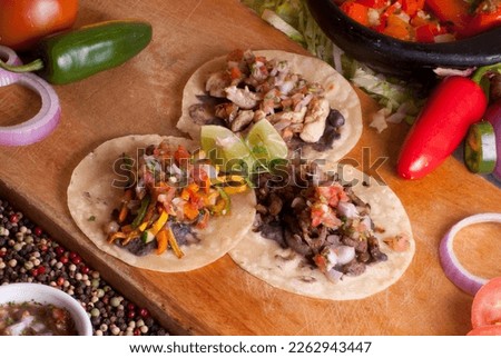 there tacos with vegetables and lemon on a wooden table