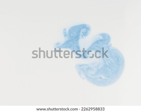 Abstract background in the form of paints dissolved in a white liquid. View from above. Closeup