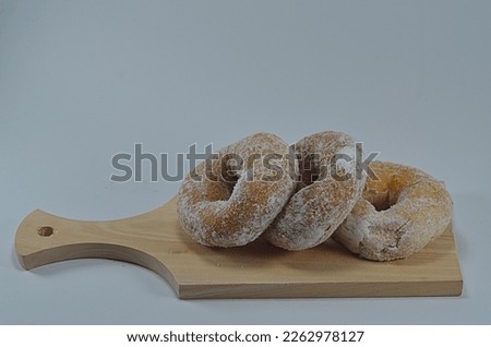 some donuts sprinkled with powdered sugar placed on a wooden board, Yogyakarta, Indonesia. shooting is done from a higher angle than the object or high angle