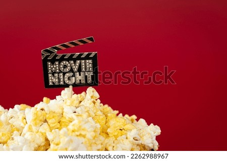 Cinema concept: delicious butter popcorn. Sign "Movie night"at home.