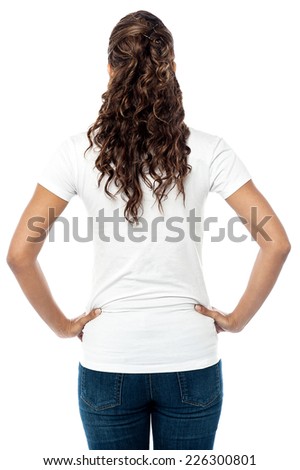 Rear view of young woman with hands on her waist 