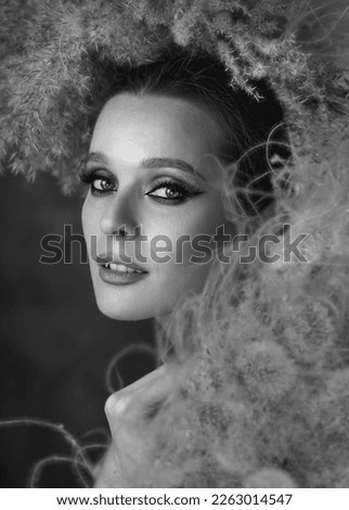 Photo session with dandelions. Beautiful girl in a hat. Model and spikes. Romantic girl. Natural image.