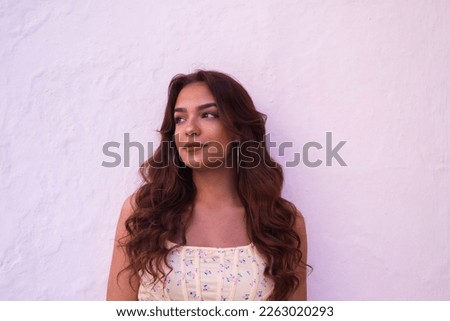 Beautiful young woman with long curly hair on a white background makes different expressions. Laughter, hate, sadness, smile, tired, admiration, surprise, happiness. Concept different expressions