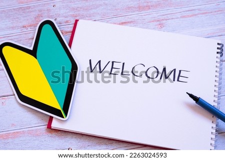 A photo of a beginner's mark and a welcome letter written in a notebook Royalty-Free Stock Photo #2263024593