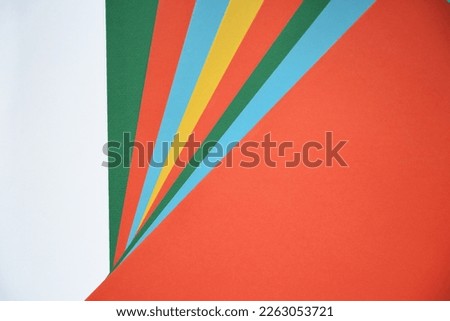 Red, white, green, yellow and blue triangle papers. Letter shaped background, wallpaper.