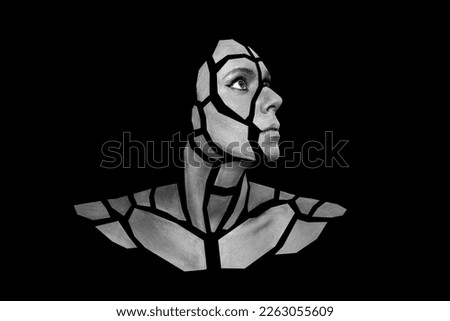 Portrait of person with art creative grey makeup posing in the studio. Shape of gray polygons on beautiful face, shoulders, neck. Pieces of face isolated on dark background.