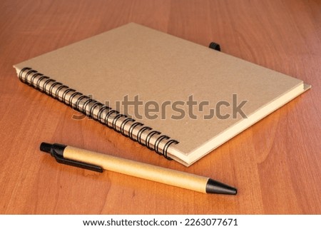 One notebook and pencil on the office desk, close-up.