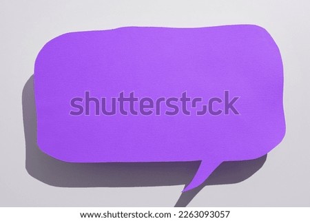 Color paper in shape of dialog box with important message. Infromation written on sticker. Different office stationery. Calculator, pencils, pens laing white table.