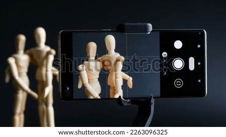 Mobile phone photographs the relationship between two mannequins. The concept of hidden shooting, paparazzi and photo shoot. Golden Ratio Grid Markup. Close-up. Royalty-Free Stock Photo #2263096325