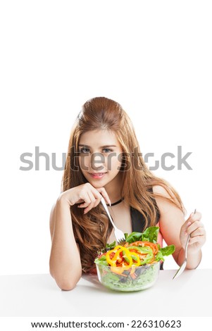 Young woman pretty attractive presenting and eating salad. Portrait of beautiful smiling and happy mixed Asian brunette woman enjoying a healthy salad and cherry tomatoes snack
