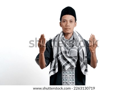 Religious muslim asian man wearing turban, muslim dress and cap, praying to God. Isolated on white background.