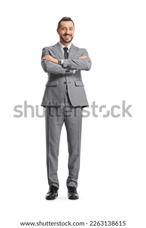 Young cheerful businessman posing with crossed arms isolated on white background