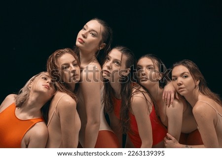 Youth, beauty, attraction. Group of young beautiful girls in bodysuits posing over black studio background. Contemporary dance style. Concept of art, movement, youth, fashion, artistic lifestyle Royalty-Free Stock Photo #2263139395