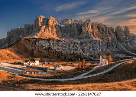 Gardena Pass, Italy - Panoramic view of the Brunecker Turm mountain (Mur del Pisciadu) belonging to the Sella group in the Italian Dolomites in South Tyrol, Italy with small chapel and a warm sunset Royalty-Free Stock Photo #2263147027