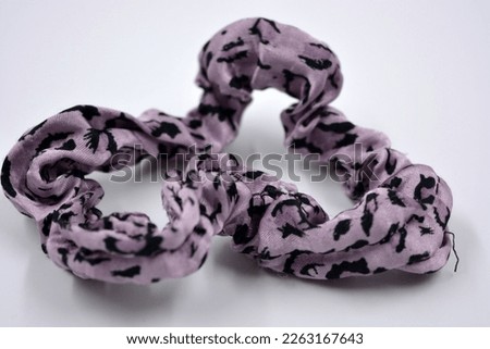 An interesting women's fabric elastic band made of purple with black dots of hair fabric is located on a white background.