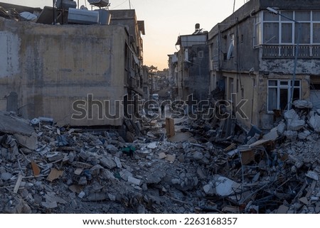 Buildings destroyed in the earthquake in Hatay Antakya and a man walking alone on the street. Royalty-Free Stock Photo #2263168357