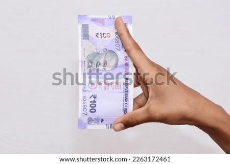 Hand holding Indian 100 rupee note Royalty-Free Stock Photo #2263172461