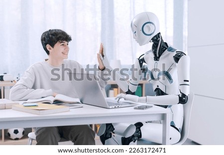 A Boy studies with the help of a Robot. The result is fruitful. Robot and Human Collaboration Concept. Royalty-Free Stock Photo #2263172471