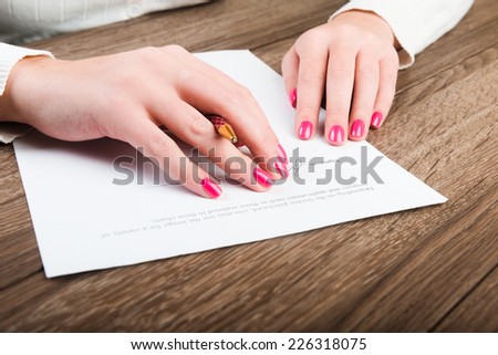 Businesswoman's hand with pen signing a contract. 