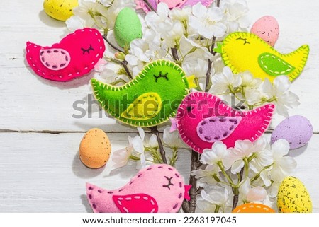 Beautiful Easter background with traditional decor. Flowers, decorative eggs, birds and rabbits. Modern hard light, dark shadow, white boards, flat lay, top view