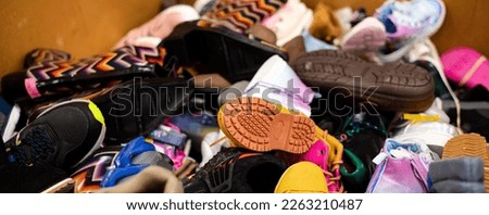 Panorama view mixed wide variety of brand-new shoes tied in rubber band in large carton box at donation center in Dallas, Texas, USA. Collection drive footwear ready for volunteer activity Royalty-Free Stock Photo #2263210487