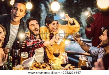 Mixed age men and women having fun drinking out at wine diner - Food beverage life style concept on happy trendy people enjoying time together at villa patio - Warm filter with bulb string lights halo Royalty-Free Stock Photo #2263226647