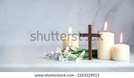 Wooden cross, snowdrops flowers and candles on table, blurred abstract background. Religious church holiday. symbol of faith in God, Christianity Feast, Easter, Palm Sunday, Lent Royalty-Free Stock Photo #2263229015