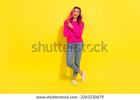 Full length photo of adorable impressed girl dressed vibrant pullover pointing empty space isolated yellow color background