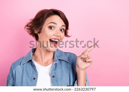 Closeup photo portrait of young attractive excited woman wear denim shirt surprise direct finger mockup stomatology isolated on pink color background