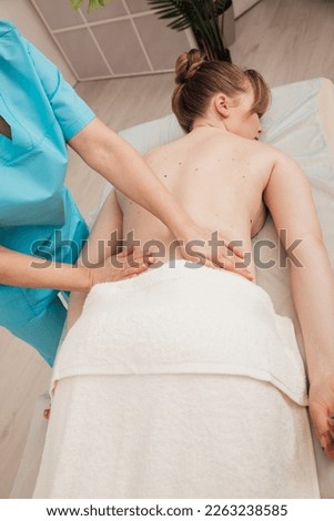 a massage therapist massages the back of a woman on the couch in the office relaxation relax osteopathy