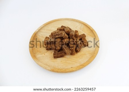 Palm sugar (in Java famous with name "Gula Jawa") is sugar that made from coconut flower essence. In this picture palm sugar shaped like cubes and arranged in wooden plate