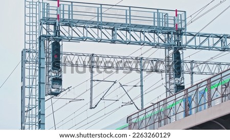 Passenger Train Passing Under Railway Track Portal Catenary Support with Signal Devices Semaphores and Electric Power Lines Royalty-Free Stock Photo #2263260129