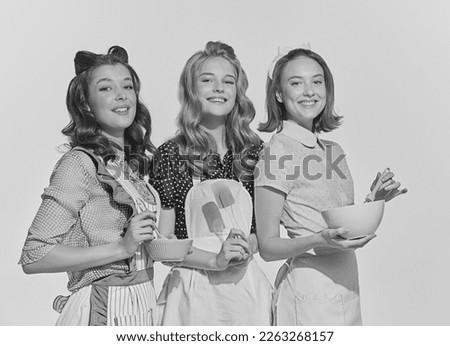 Retro style portrait of beautiful young women, housewives with cooking tools. Black and white image in vintage style. Concept of beauty, retro style, fashion, elegance, 60s, 70s, family. Royalty-Free Stock Photo #2263268157