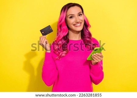 Photo of positive attractive lady hold telephone plastic debit card toothy smile isolated on yellow color background