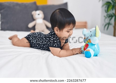 Adorable hispanic baby lying on bed at bedroom