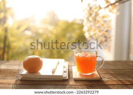 Orange juice healthy drink and  raw Orange and notebooks on wooden table