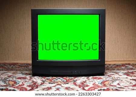 Vintage green screen TV on the floor, old house design in 1980s and 1990s style.