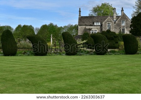 Scenic view of a beautiful English style landscape garden with a freshly mowed lawn and green leafy trees